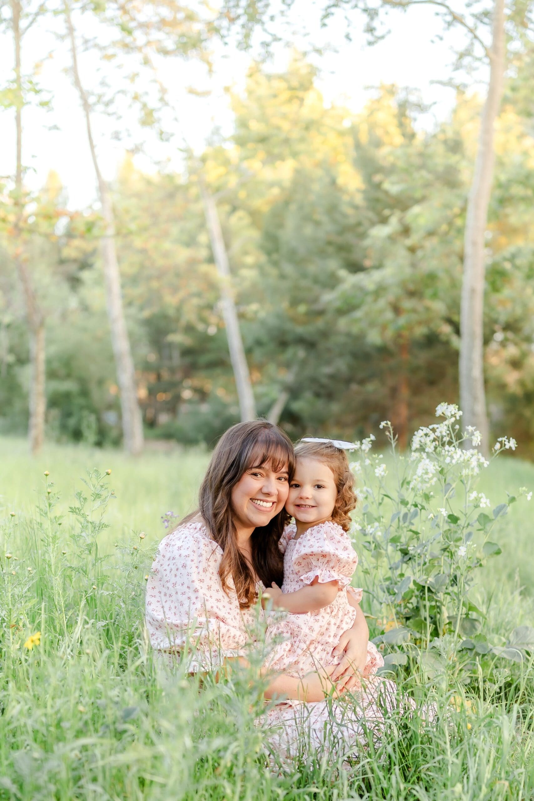 A mother and daughter share tender moments together in a wildflower meadow during golden hour while in Orange County, Ca