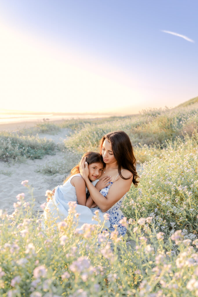 a mom hugging her daughter during a family photo session in Huntington Beach
