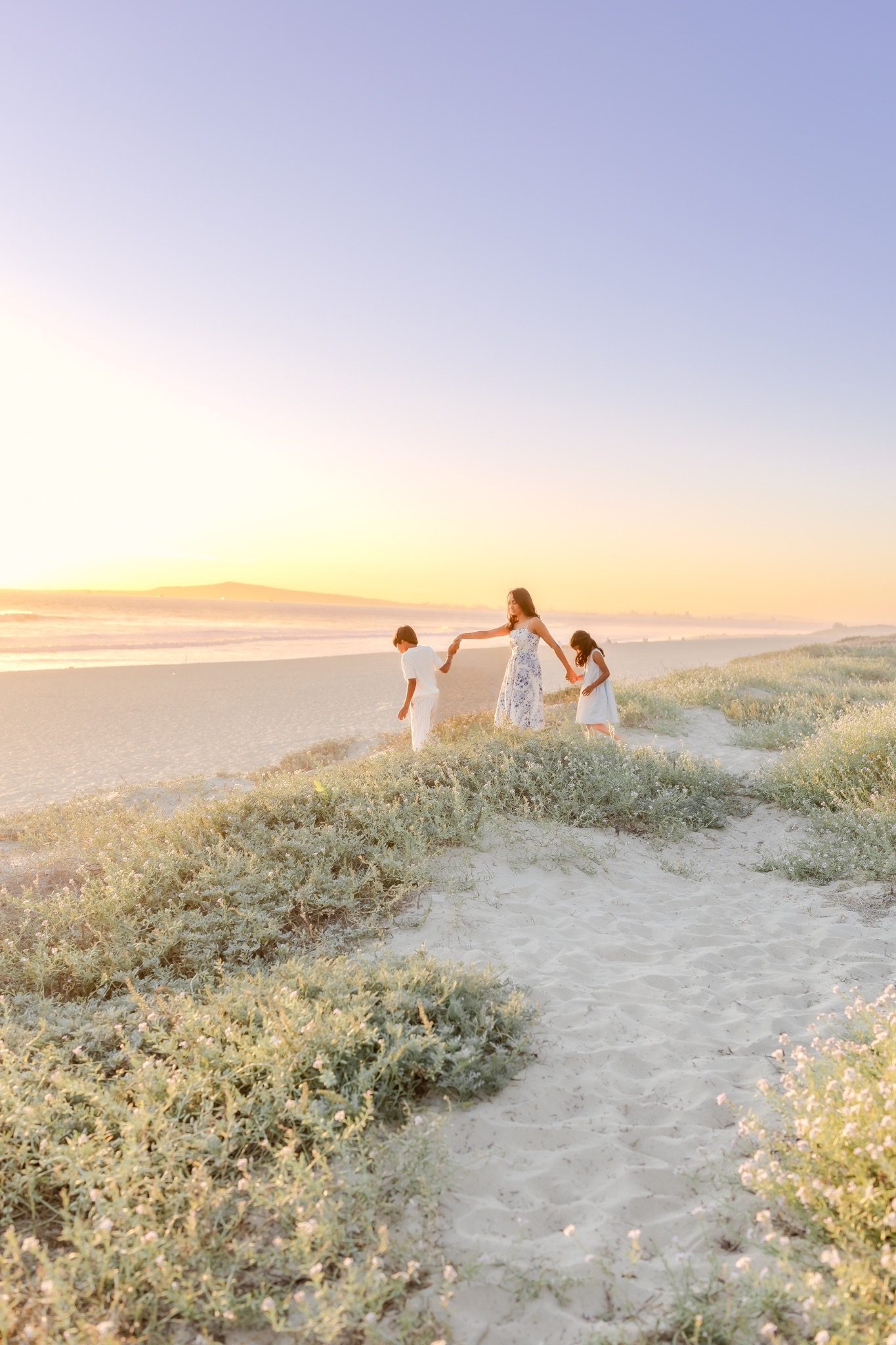 a mother and children in Huntington Beach holding hands