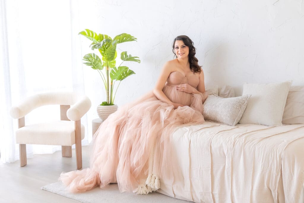 Mom-to-be laughing naturally during in-home maternity session, candid lifestyle photography