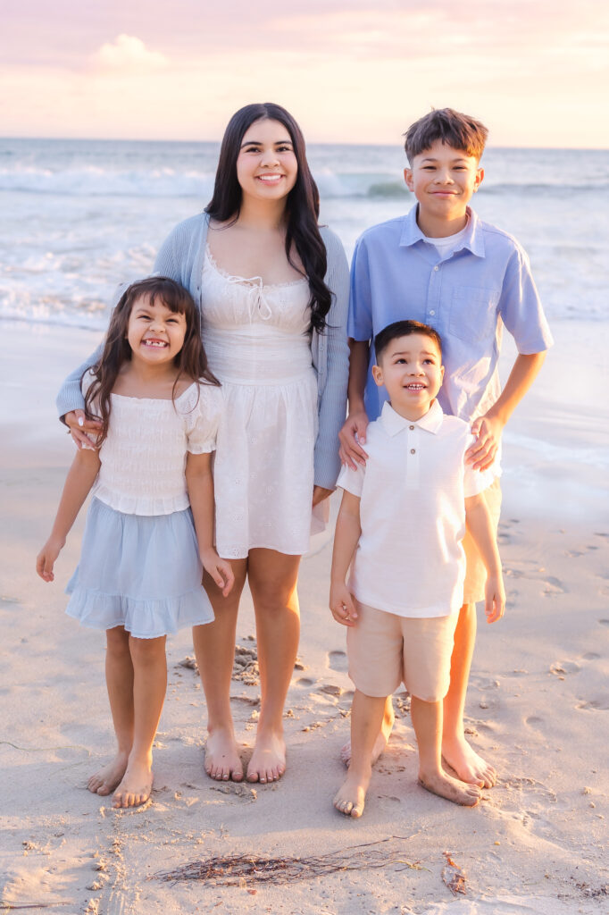 Happy family enjoying a relaxed summer evening together during a Newport Beach beach photography session.