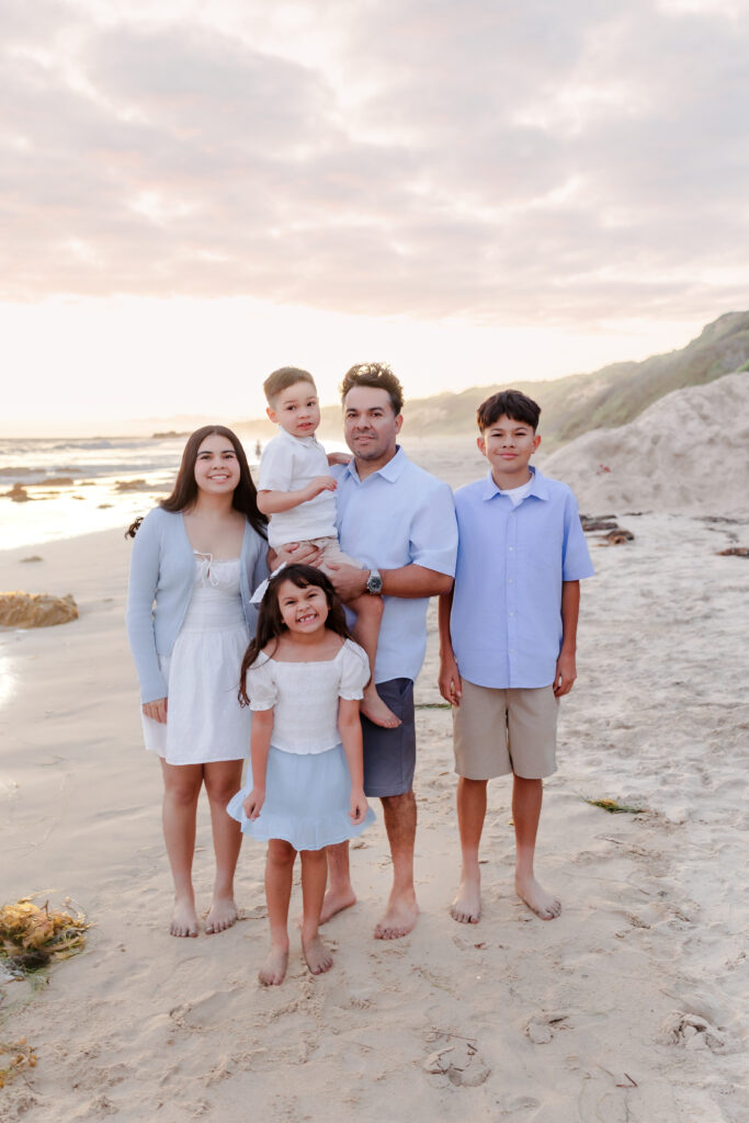 Parents laughing with their children in the golden light on a Newport Beach summer evening.