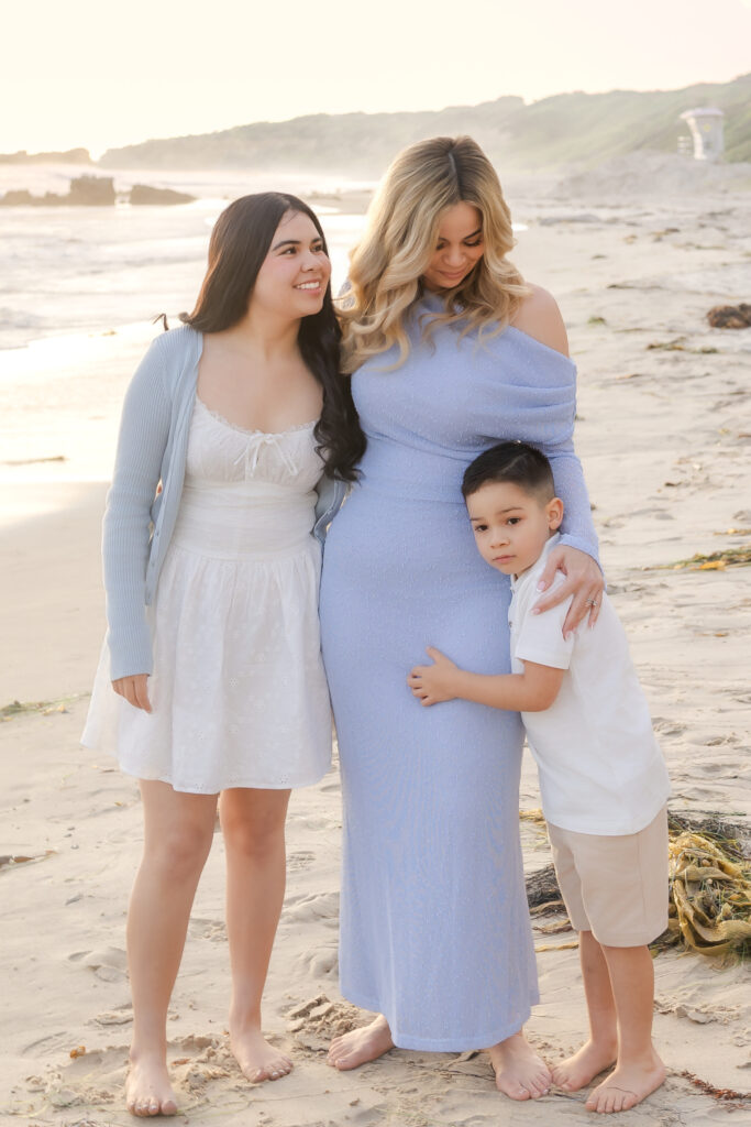Family walking together along the shoreline during a Newport Beach summer photo session at sunset.